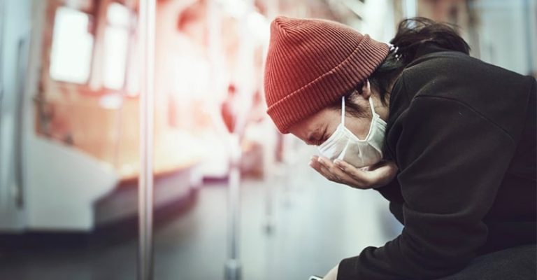 一名乘客佩戴口罩在火車上咳嗽，突顯出新冠肺炎疫情期間公共交通工具上防疫的重要性。