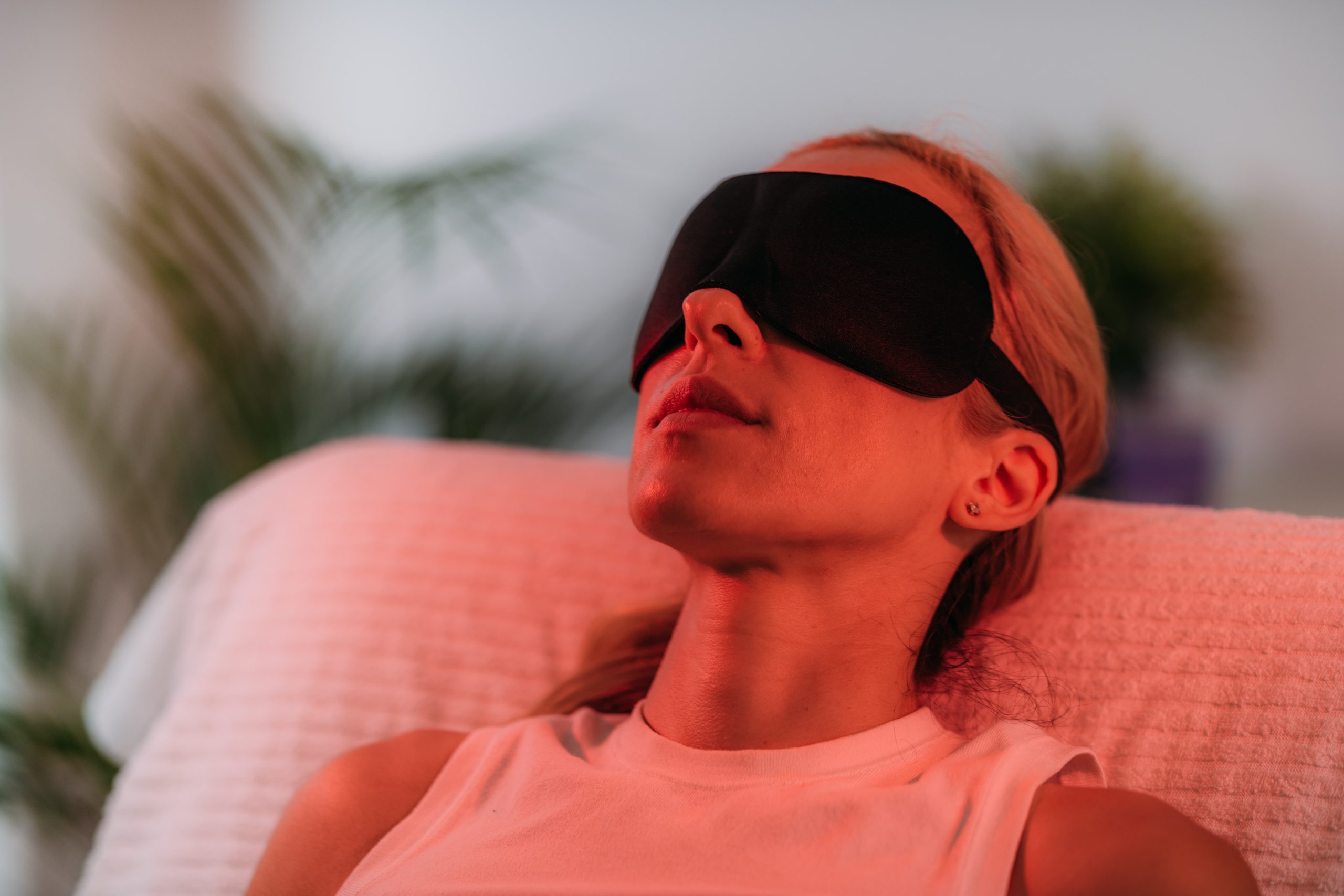 一名女子佩戴眼罩照紅光，象徵紅光照護有助緩解頭部不適與放鬆身心。