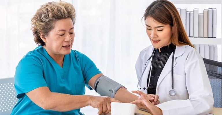 醫生正在幫一位穿著藍色上衣的中年女子量血壓，場景在明亮乾淨的診間內。