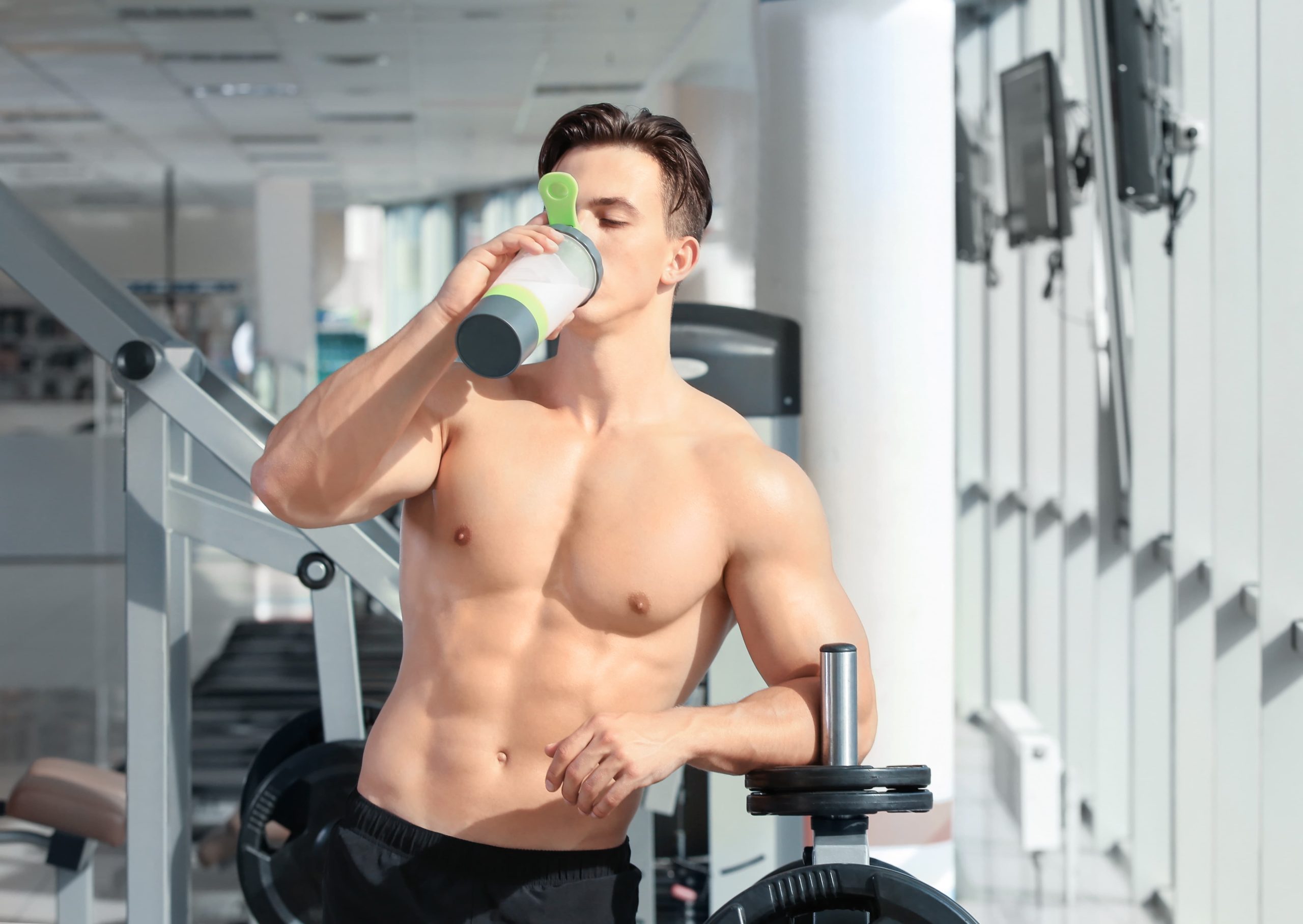 一名肌肉發達的男子正在飲用乳清蛋白粉飲料。