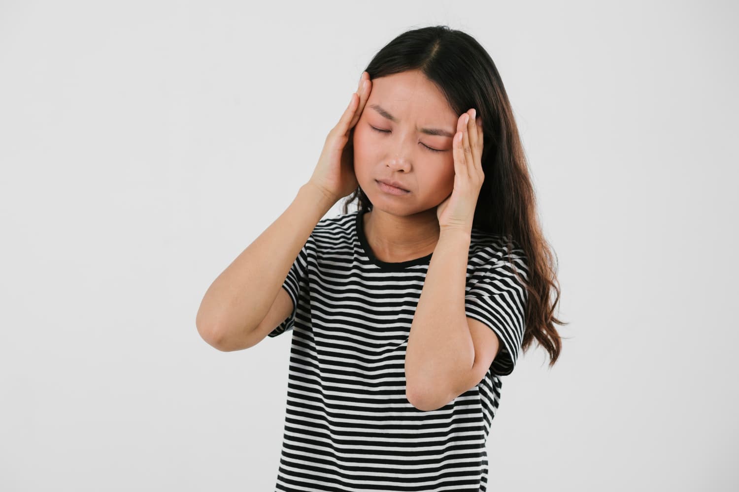 一名女子手扶著頭,表情痛苦,可能因為藍綠藻的副作用引起頭痛。