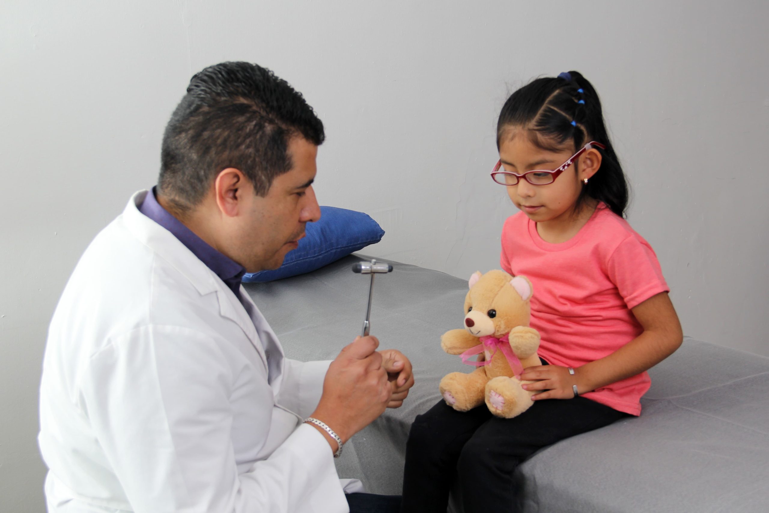 一位治療師正在與一名年幼的孩子進行近距離互動，展示了一個充滿關懷和支持的自閉症療癒環境，強調了在幫助孩子發展社交與認知技能過程中的關鍵聯繫與專注。