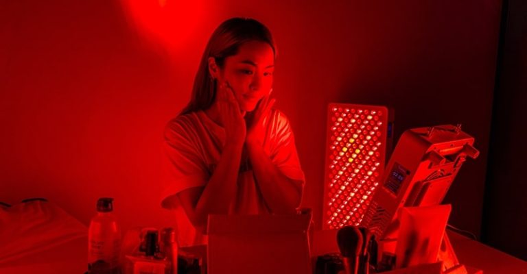 一名女子在紅光儀前進行臉部護理，有助於減少皺紋及改善肌膚健康。