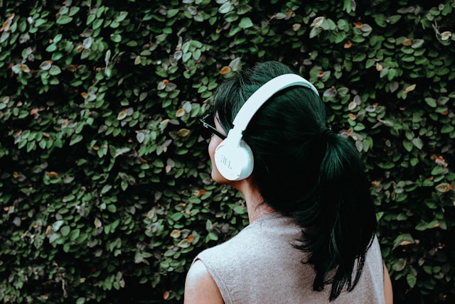 一名戴著耳機的女子在戶外聽音樂。